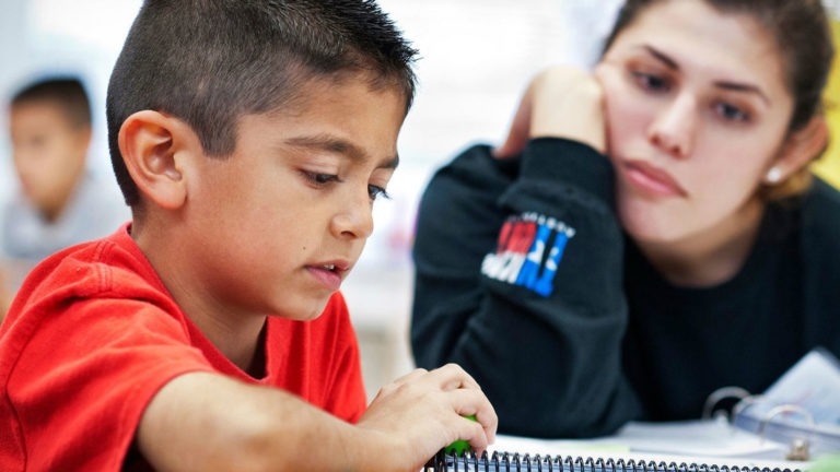 A teacher watches her student take an assessment that will give her valuable data