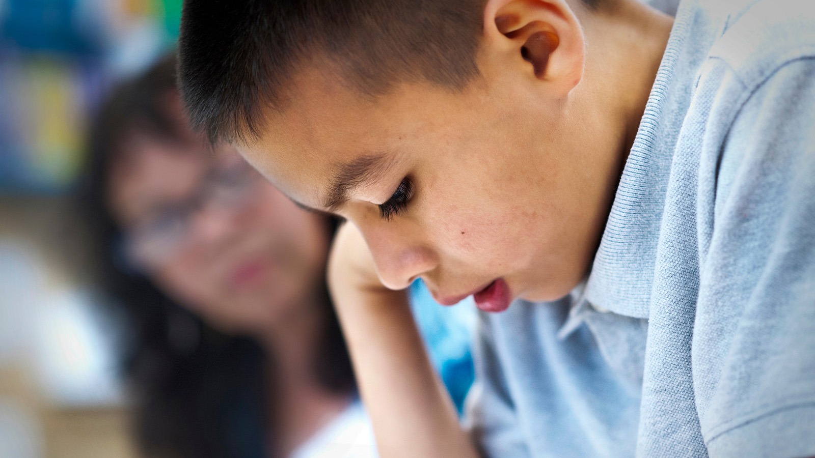 A child in a Central Texas school completes his work in the presence of a teacher