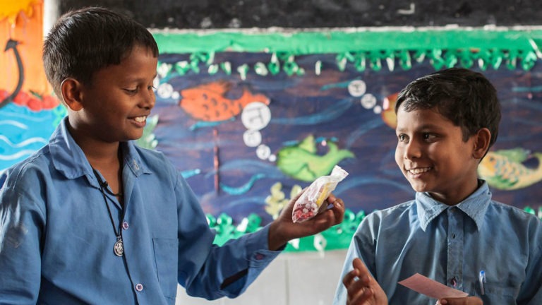 Two boys in a classroom in India participate in hands-on learning