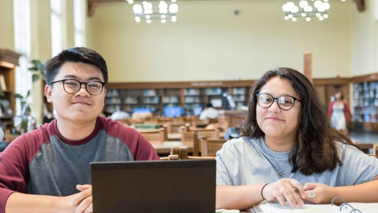 Two college students working in a library