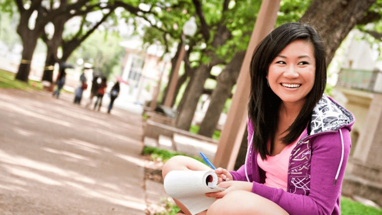 A woman studies on a college campus