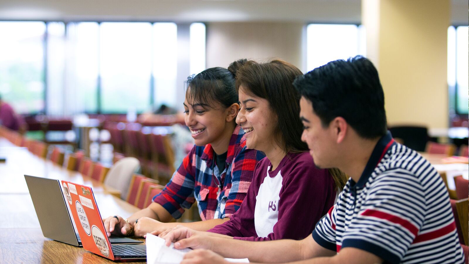 Three college students studying together in a library