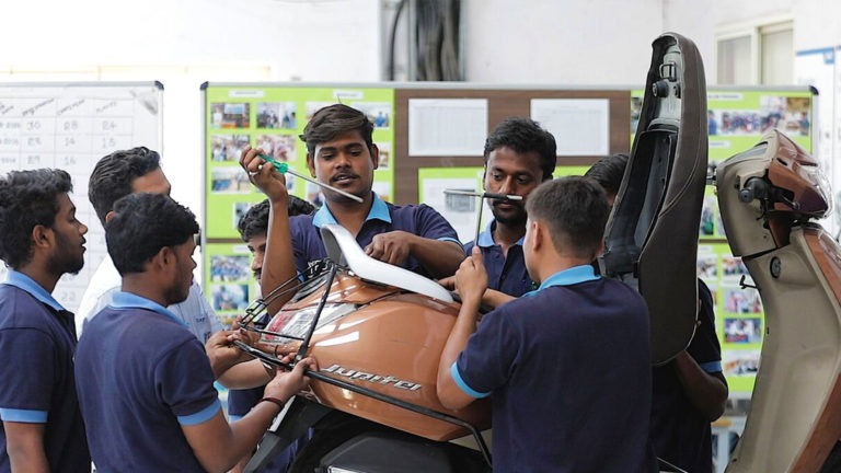 Workers in India repairing a scooter