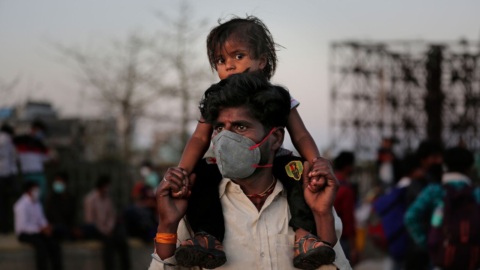 An Indian father in a face mask with son