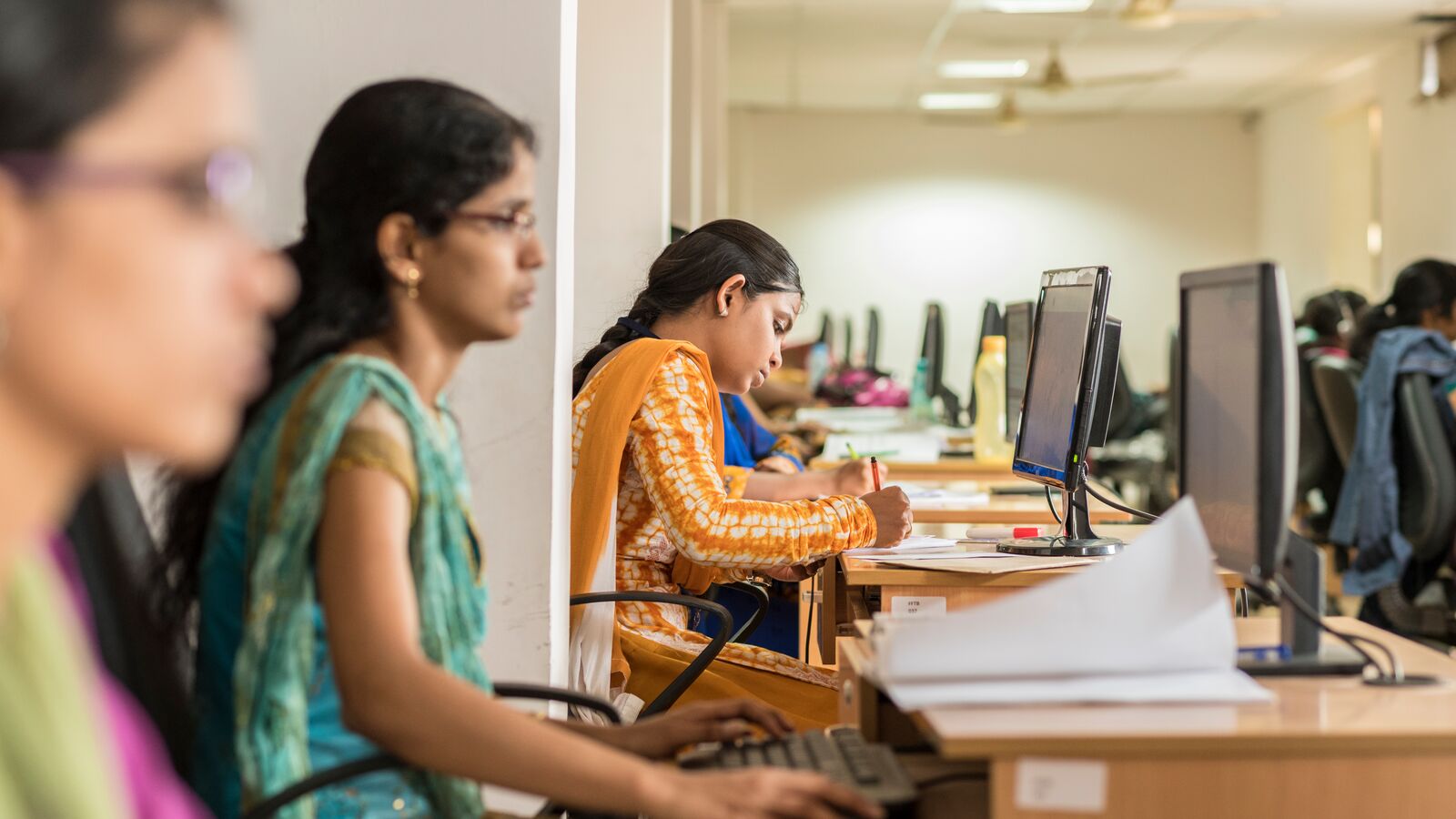 A young indian woman working at a computer for supported Jobs and Livelihoods