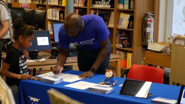 Boston Saves team member working with a young student