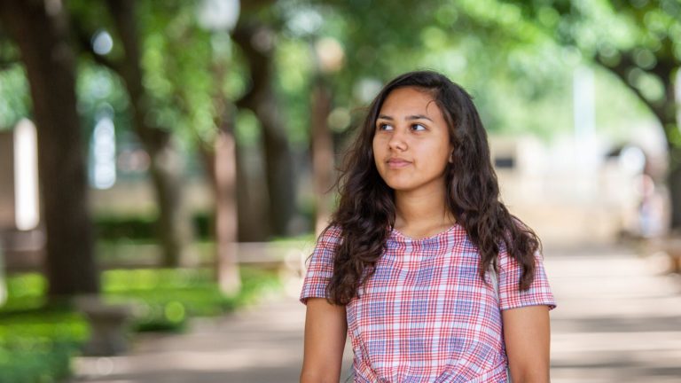 A future physician walks on the campus of UT Austin after attending Dell Medical School's Health Sciences Summer Camps