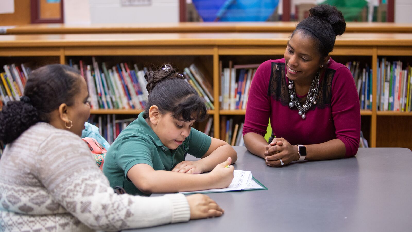 Mother and daughter working with principal