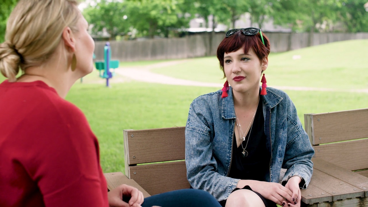 Two women sit on park benches outside the Settlement Home for children in foster care