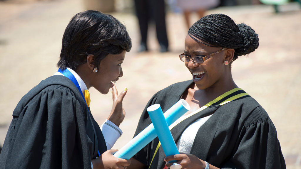 Two South African university graduates celebrate at commencement.