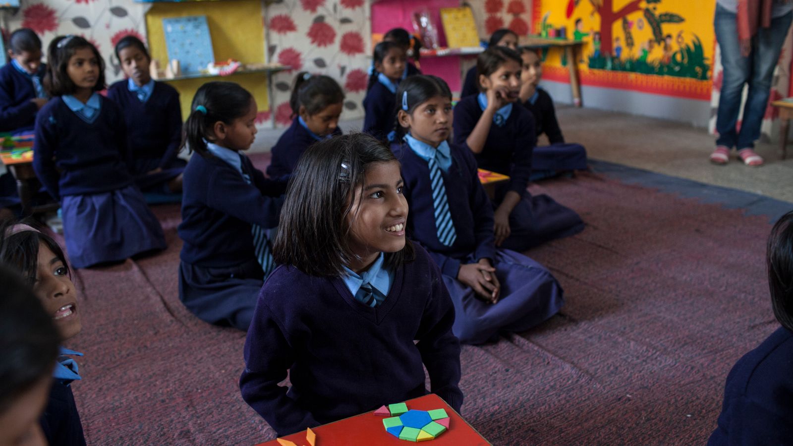 Students listening to a teacher in a classroom in India