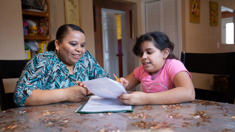 A mother helping her daughter with a homework assignment