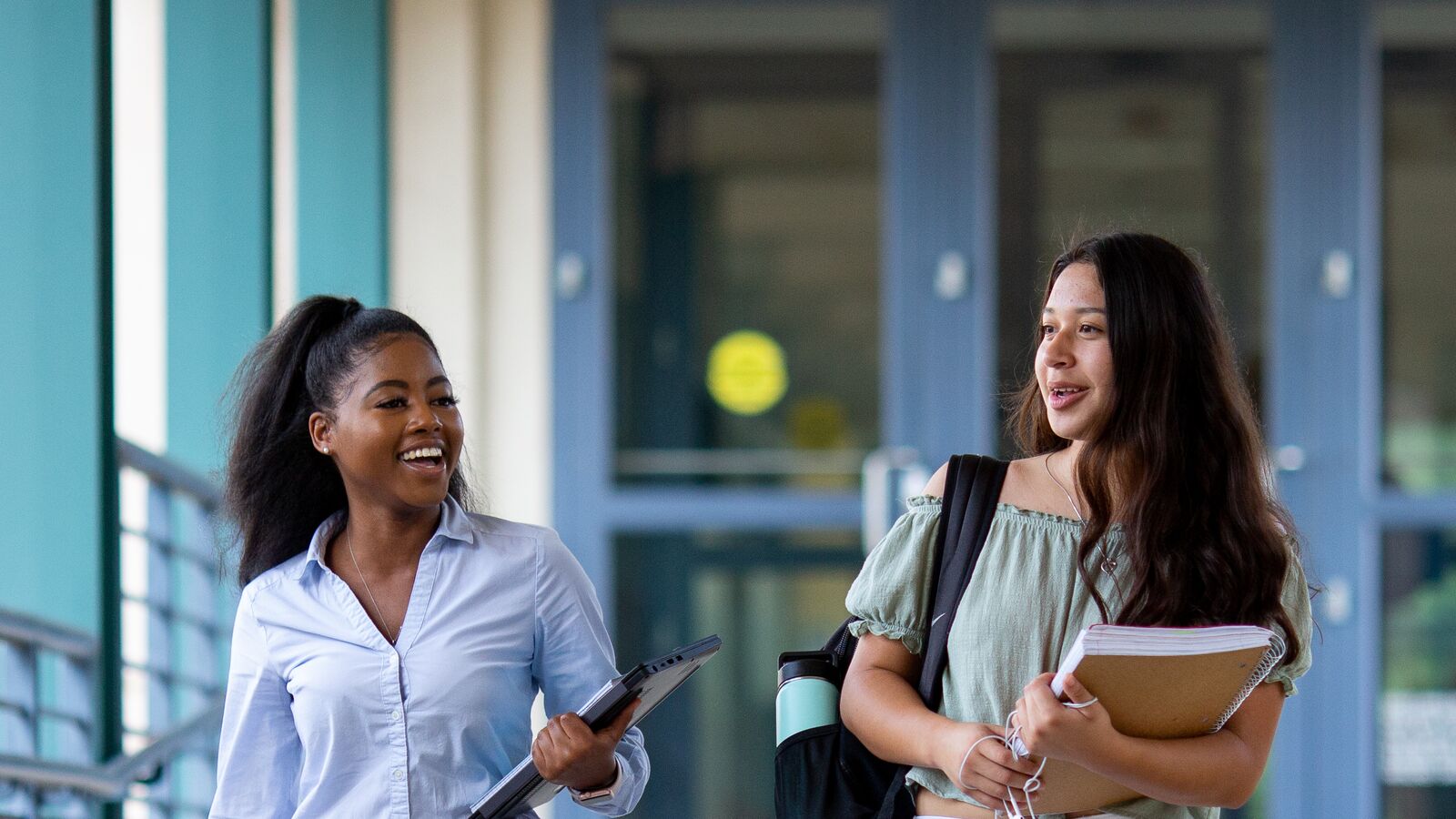 Two college students walking and talking on campus