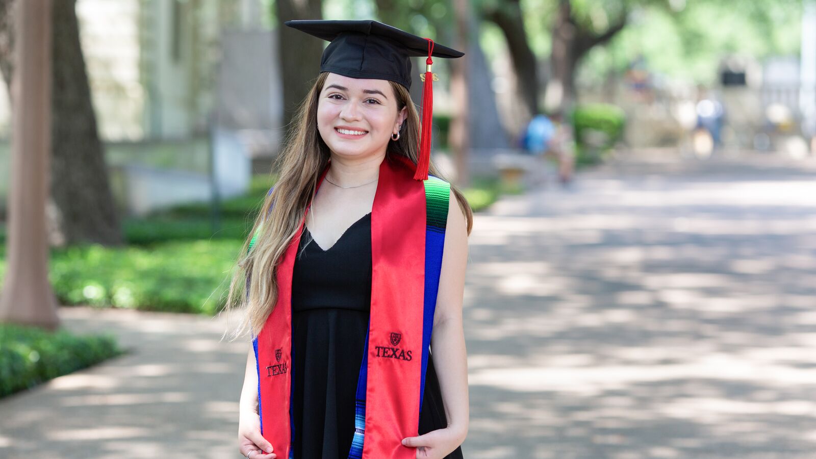 Smiling student, Abilene, wearing graduation regalia.