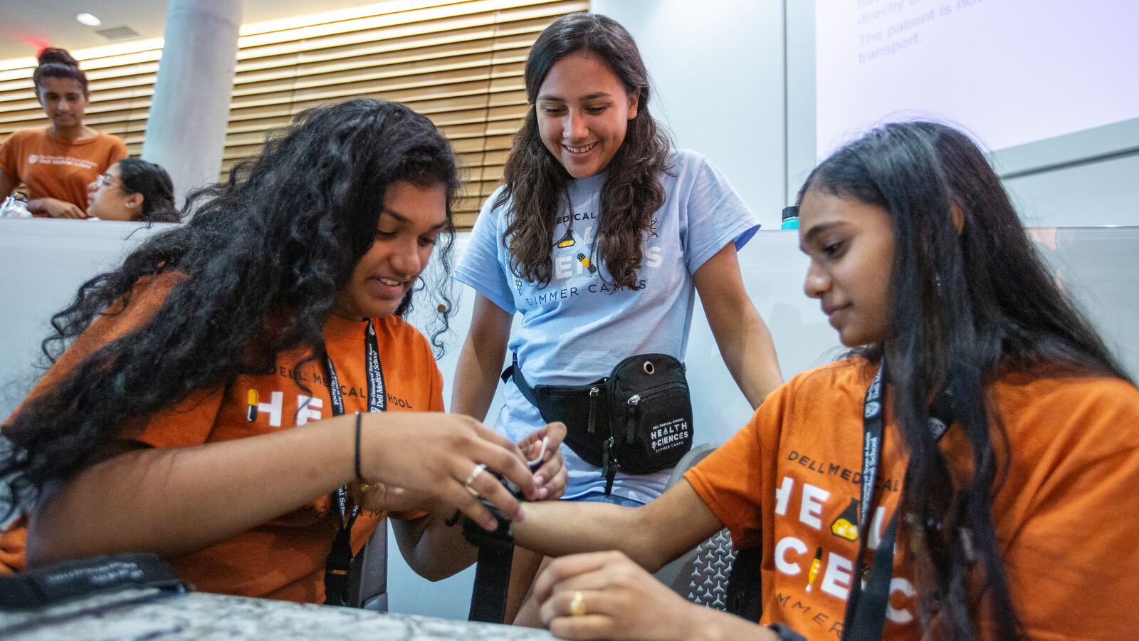 Three participants of the Health Sciences Summer Camps practice medical skills