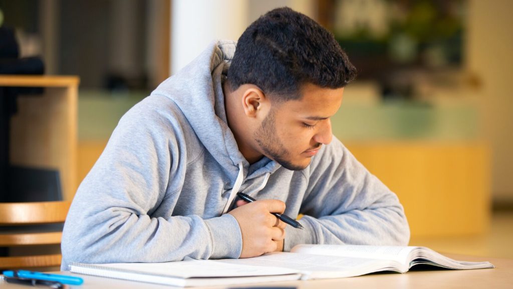 First-generation college student Chris works on an assignment. 