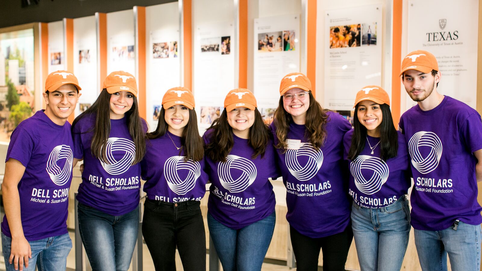 Dell Scholars at UT stand together wearing Longhorn caps.