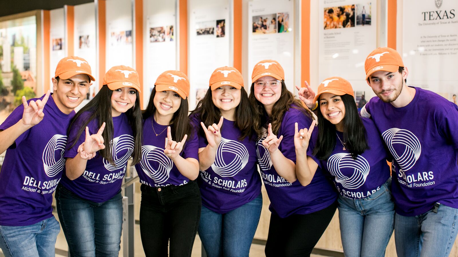 Dell Scholars at UT stand together wearing Longhorn caps.