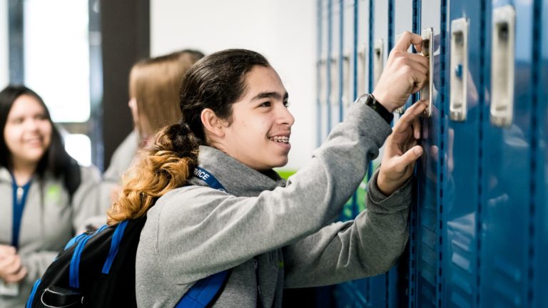 A young man opens his locker