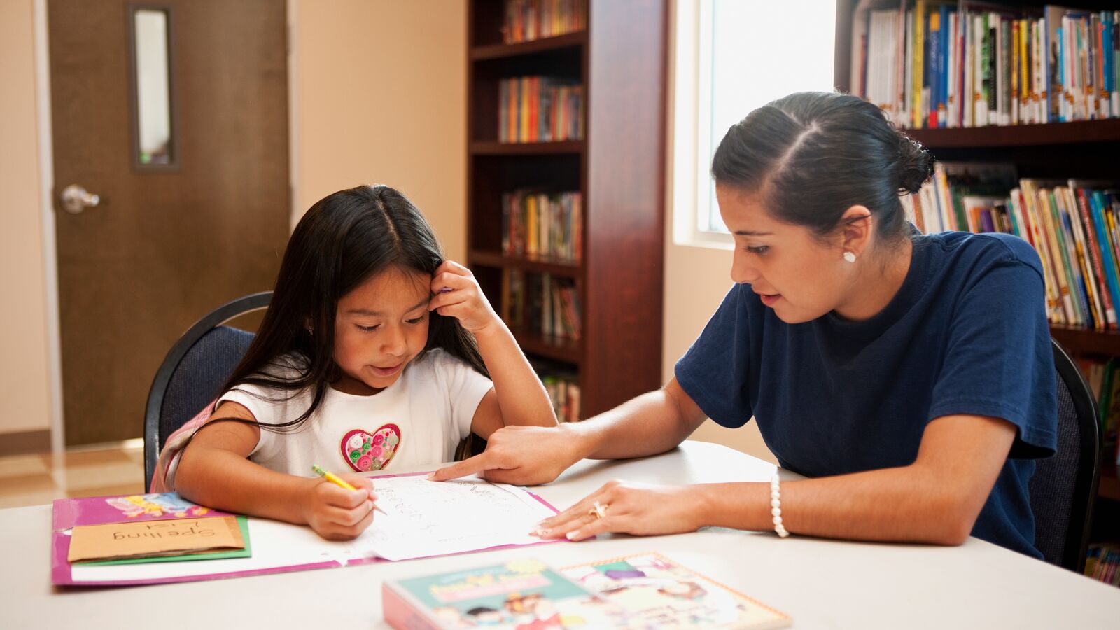 A guardian and child in Central Texas sit together at a table