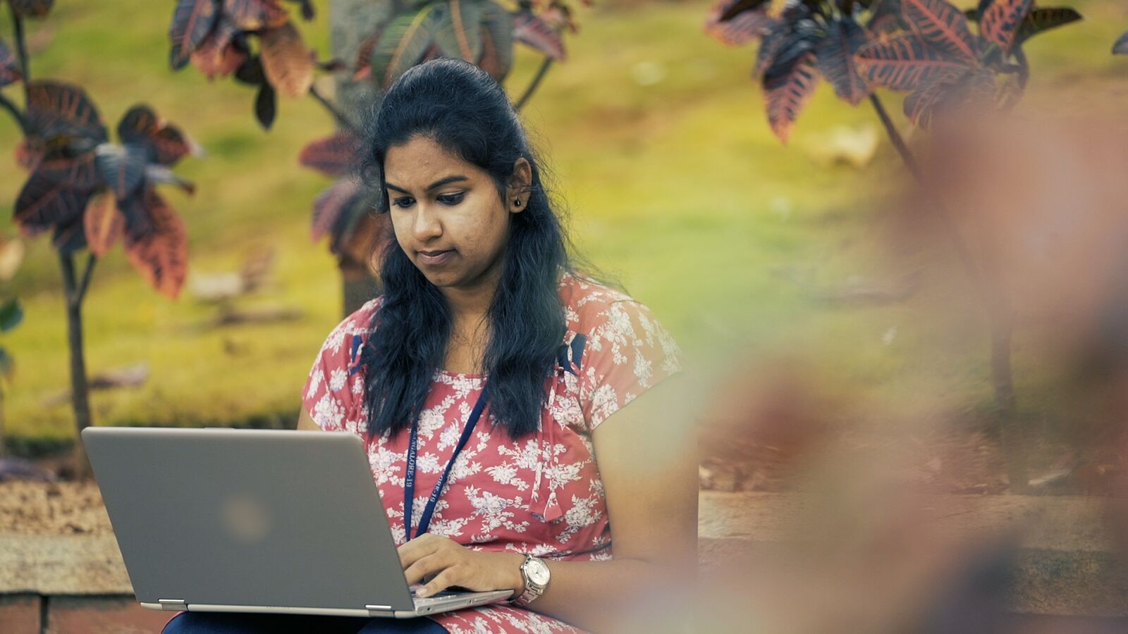 Foundation for Excellence scholarship recipient Supreeta works on her laptop outside.
