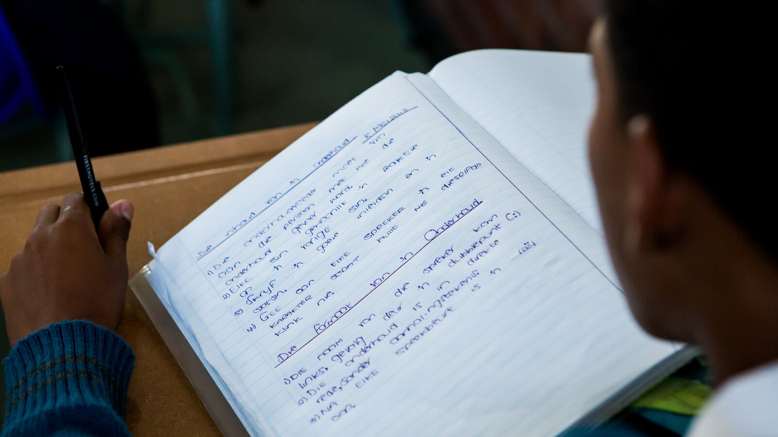 A student from Apex High School, a no-fee public school supported by Acorn Education, work on an assignment at his desk