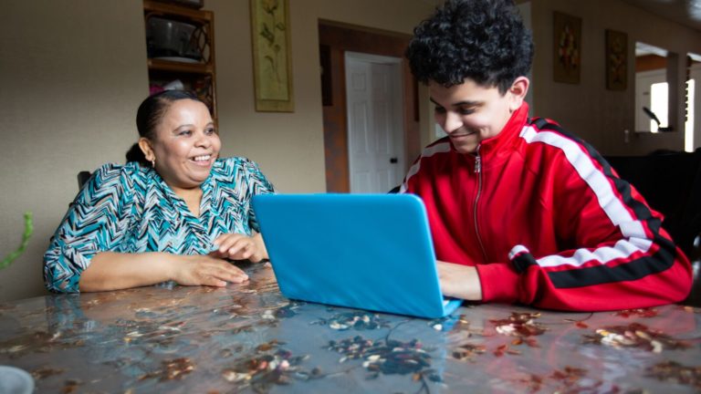 A mother and son work together on a school project