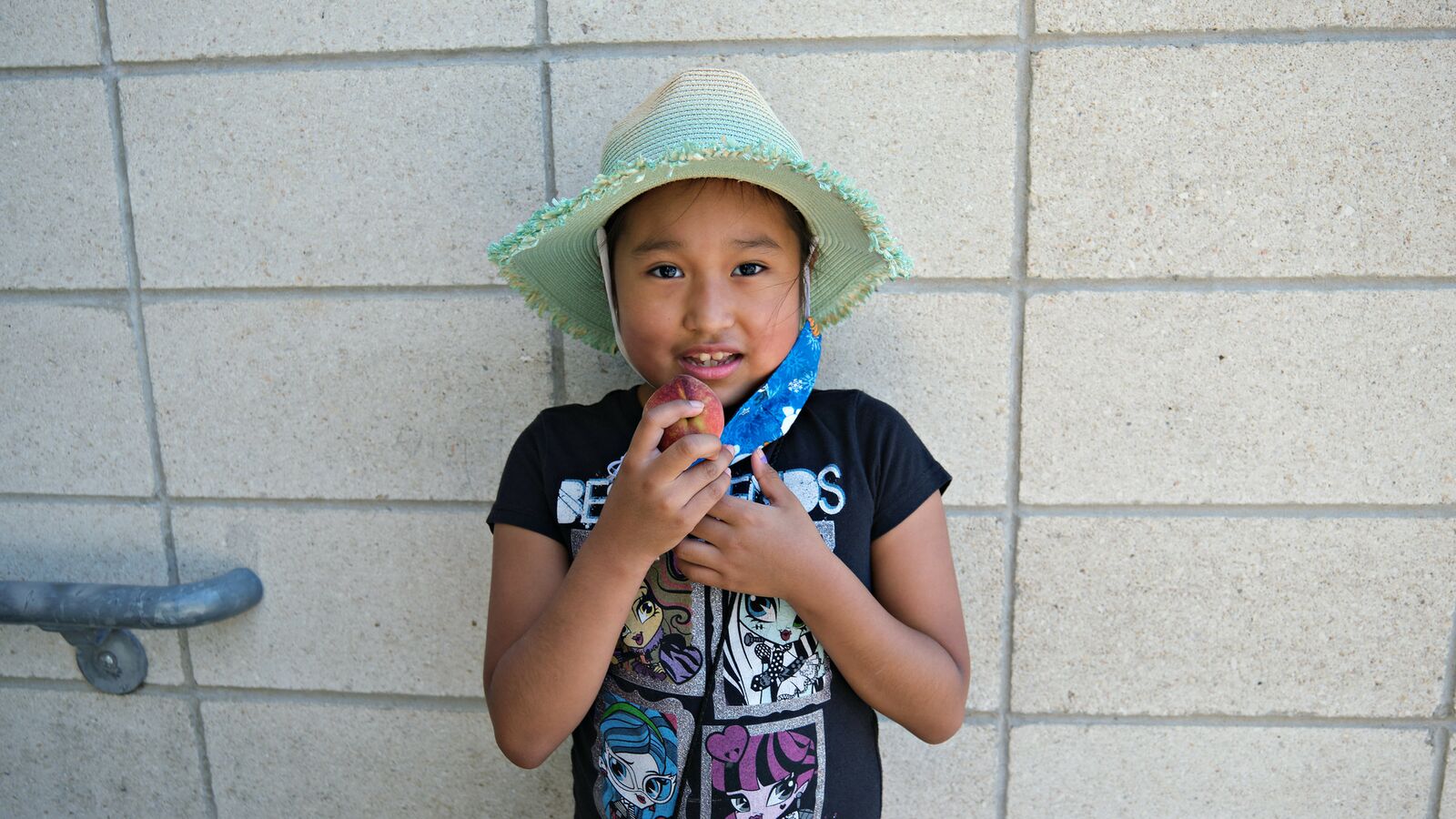 A student at a school supported by the Urban School Food Alliance eats a peach