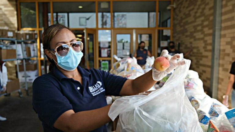 A food service worker packages food for students