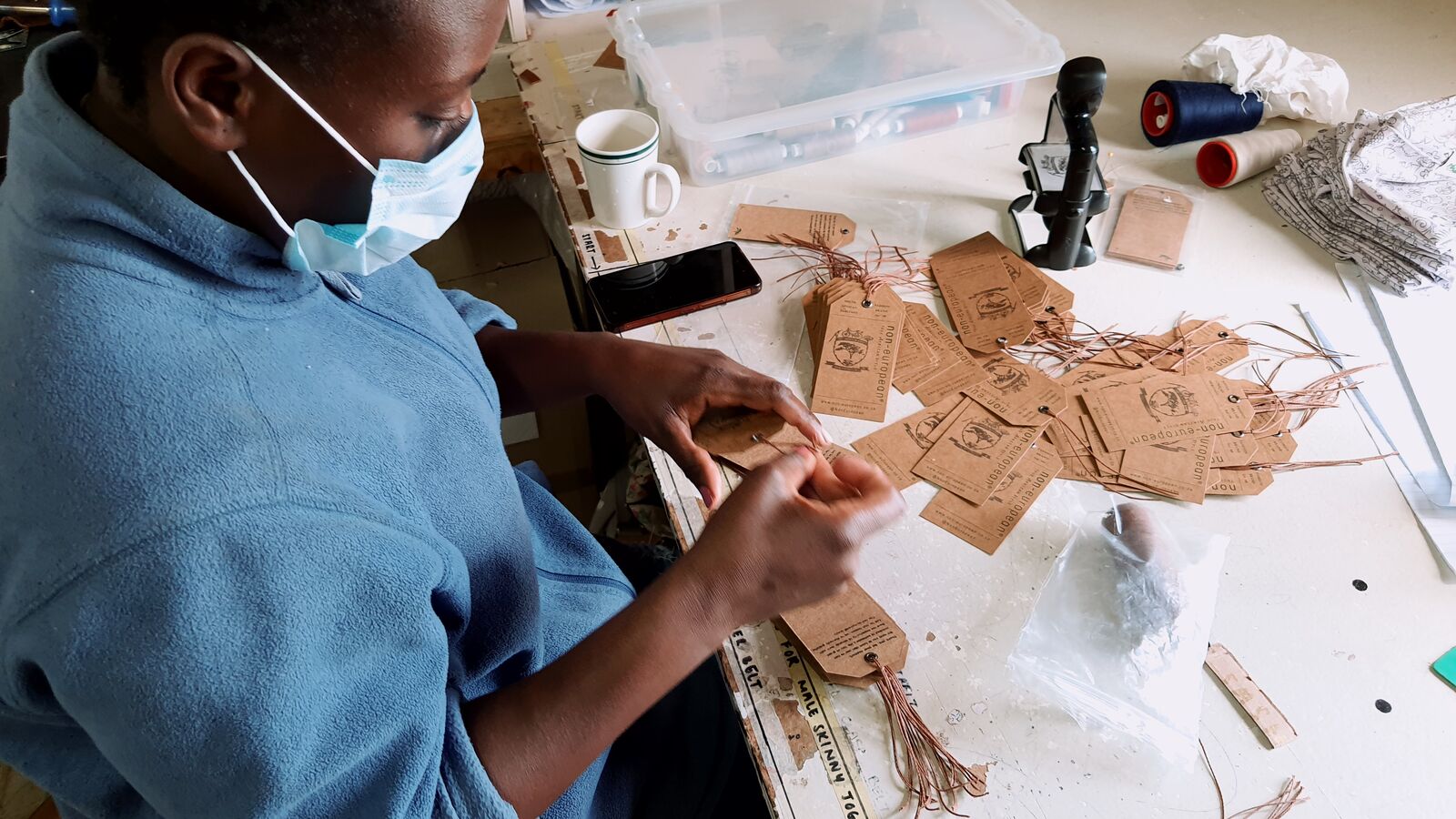 A worker at non-european clothing creates product tags