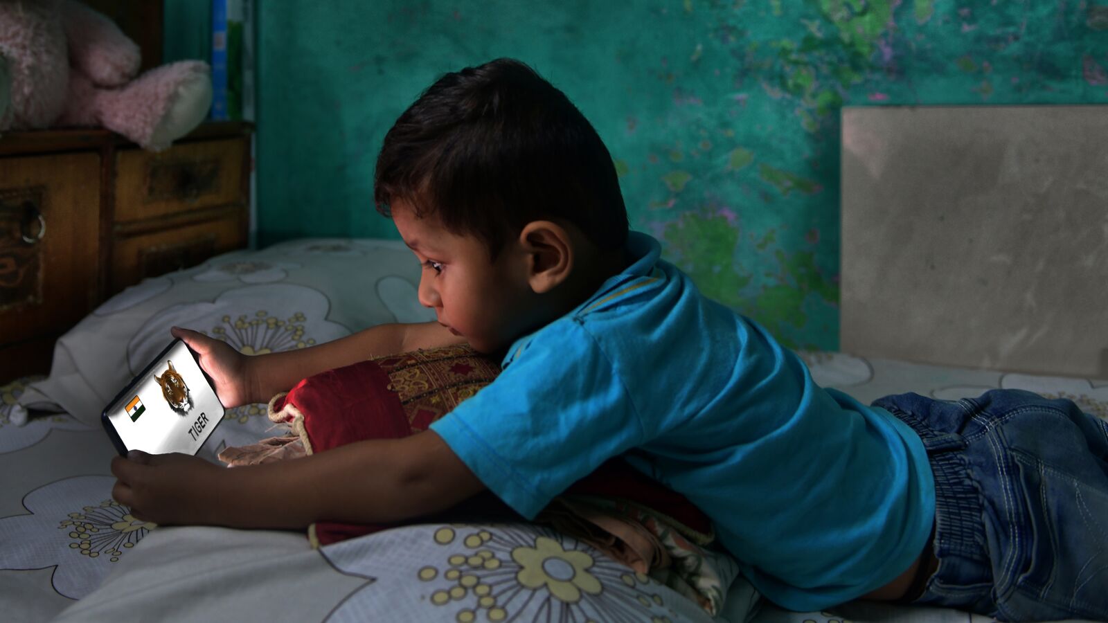 A child in India works on school assignments using a mobile device