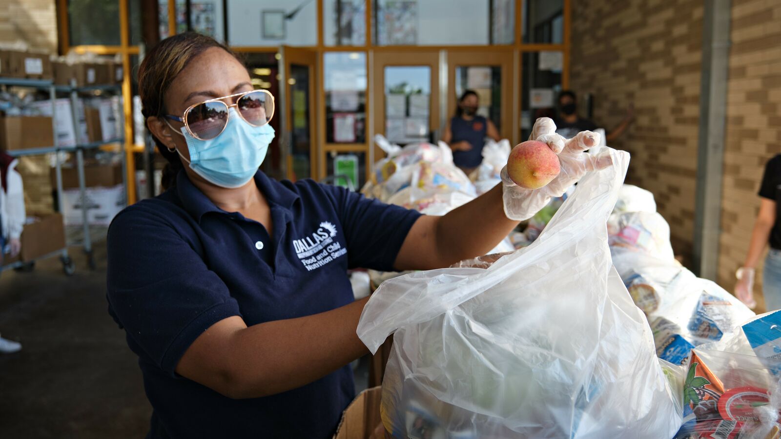 A staff member of a school supported by Urban School Food Alliance organizes meals for distribution in Dallas.