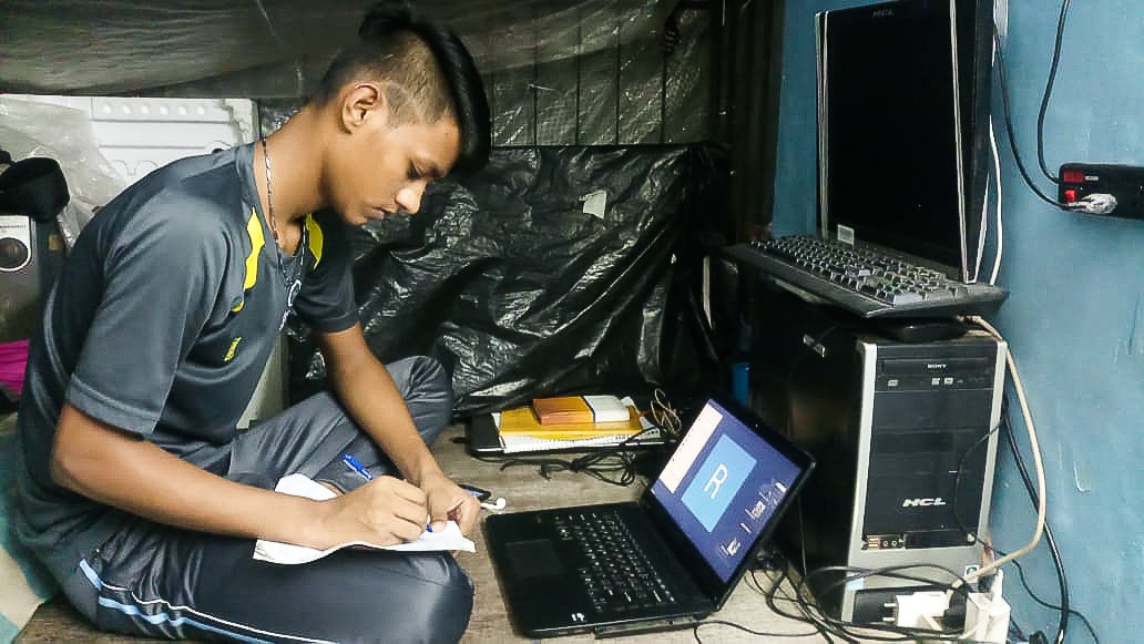 A Masoom night school student in India works on an assignment.