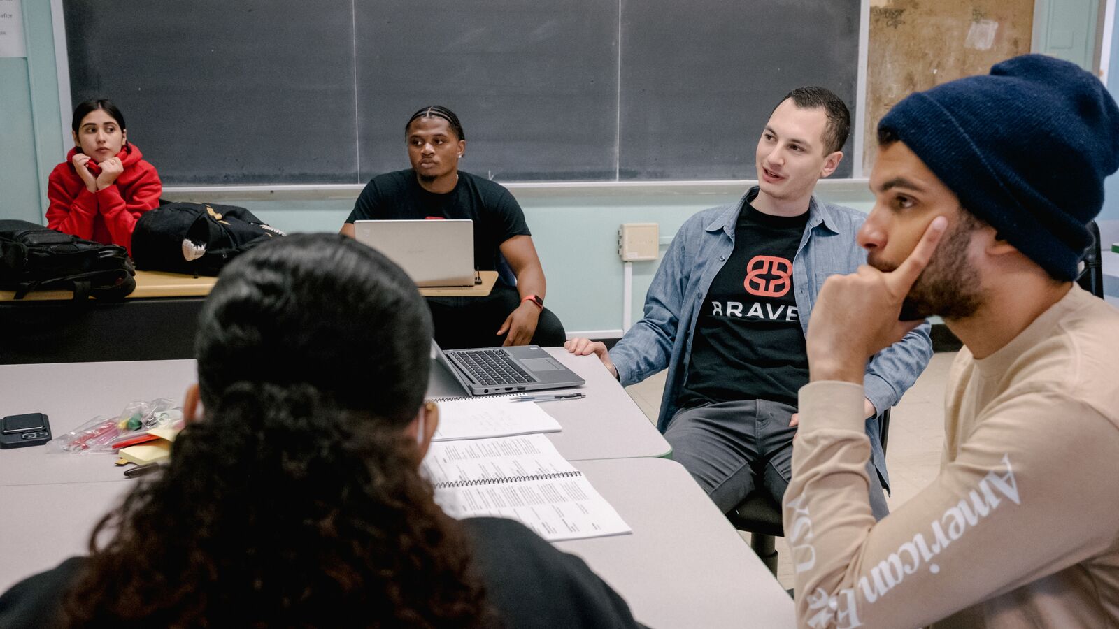 Group of Braven fellows convening in Learning Labs sitting around a table.