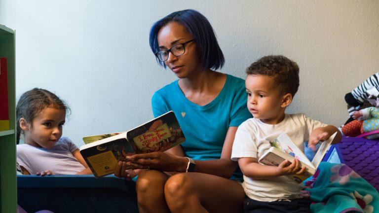 An adult learner reads to her children in her spare time
