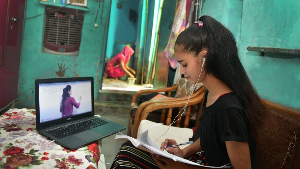 A student in India engages in online learning on a computer in her living room.