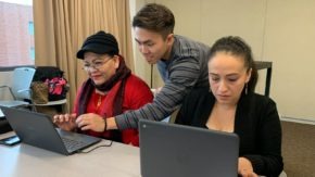 Two people in Boston work on computers to gain digital skills through Tech Goes Home