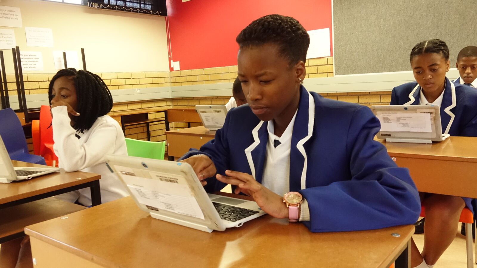 A South African student uses a computer in her class to work on math