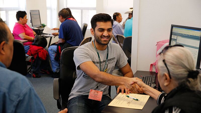 A Foundation Communities team member shakes the hand of a resident