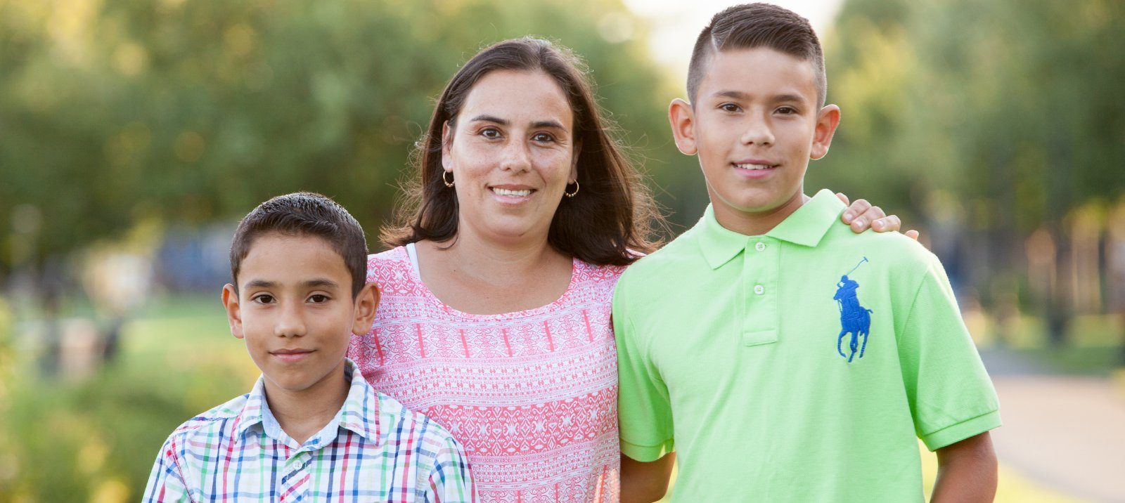 A mother and her two children supported by UpTogether poses outdoors