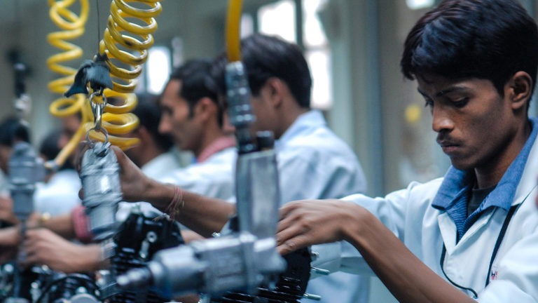 A young Indian man works in a shop.