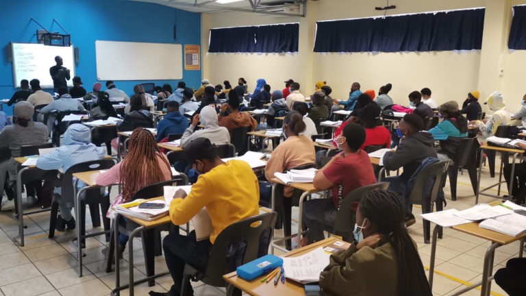 South African students attend a lecture in a classroom.