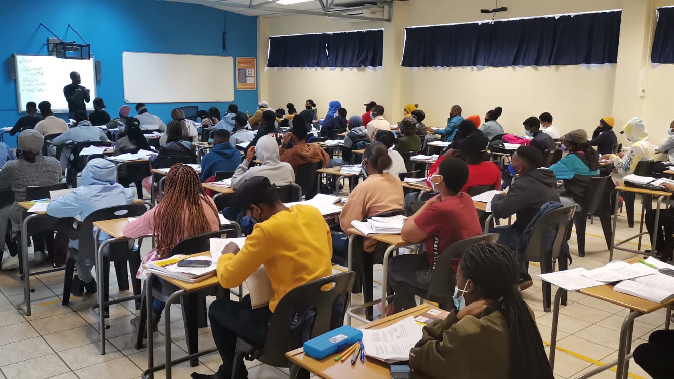 South African students attend a lecture in a classroom.