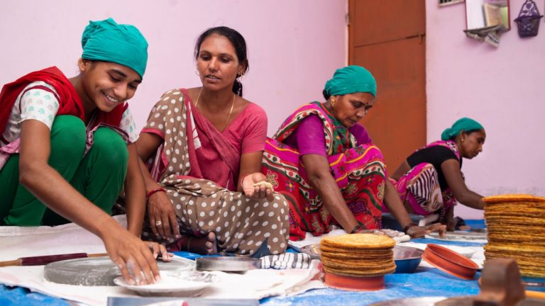 A group of Indian women make roti
