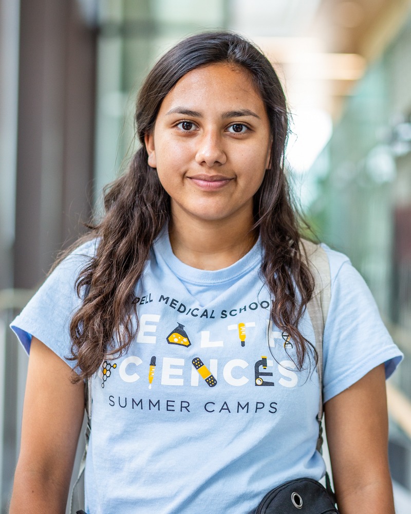 Portrait of Gabby in her Science Summer Camp tshirt smiling direct to camera.