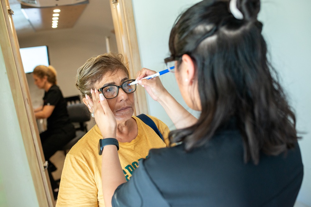 A woman working with an eye care provider to measure for custom lenses in the optical Prime mobile eye clinic. 