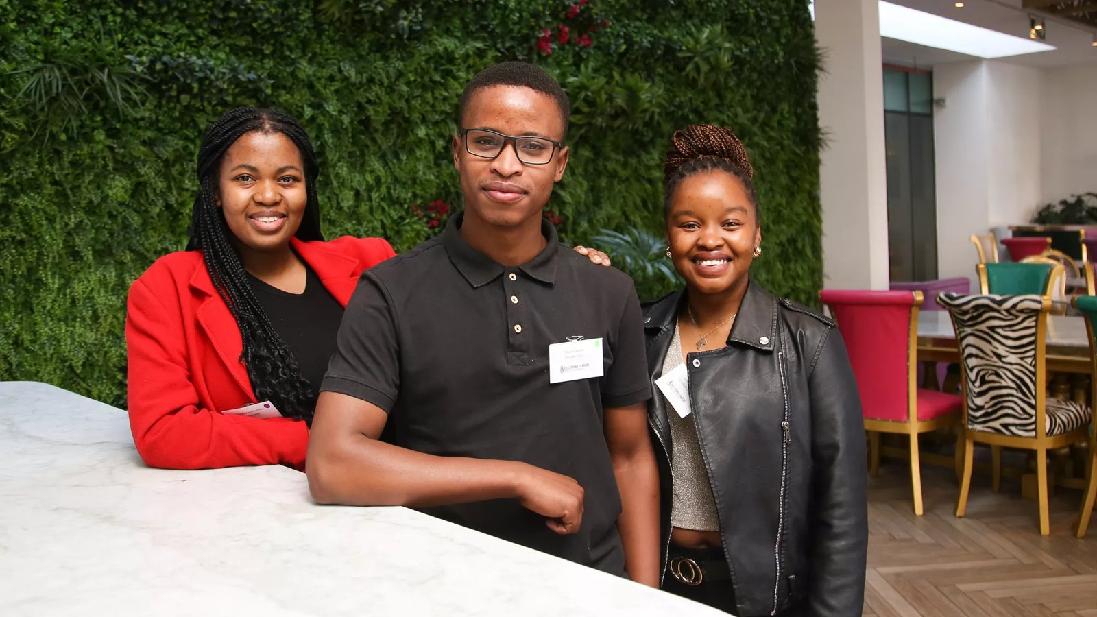 Three Dell Young Leaders alumni at the Dell Young Leaders Alumni Networking Event in Johannesburg on July 8, 2023. One male alum in the center, two women on either side smiling.