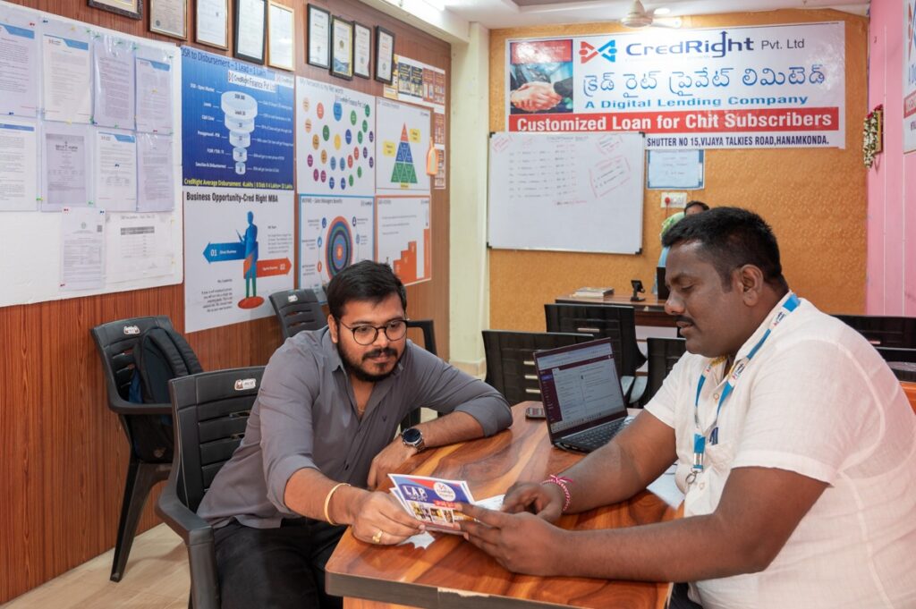 Photo of a CredRight agent and customer reviewing documents inside a CredRight office.