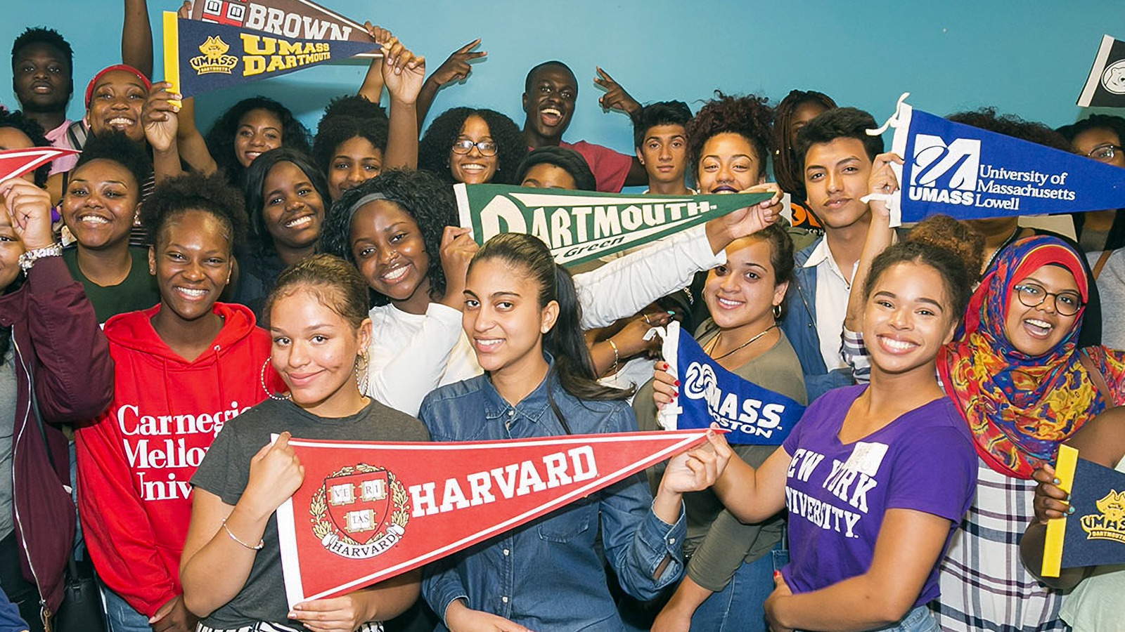 A group of Let's Get Ready participants showing off their college pride with specific university banners.