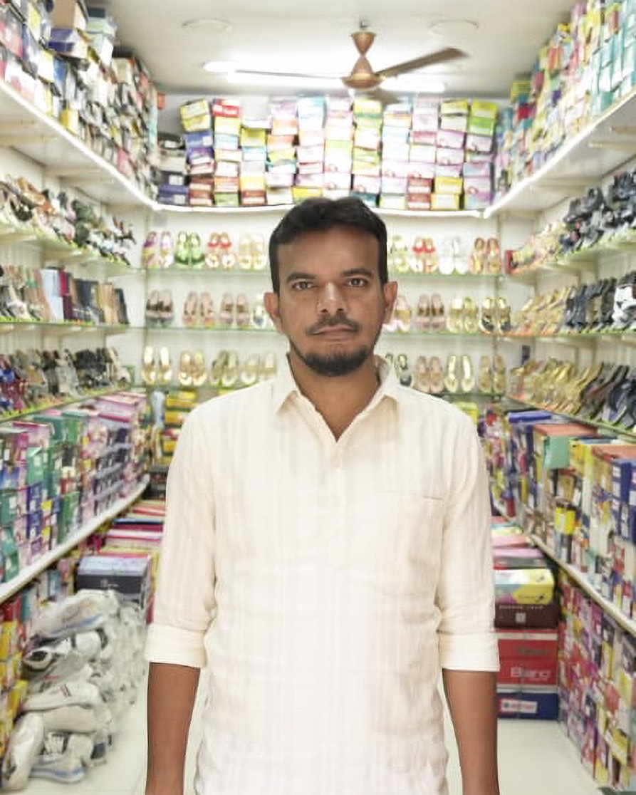 Portait of Mohammed, a shop owner, standing in his retail outlet.
